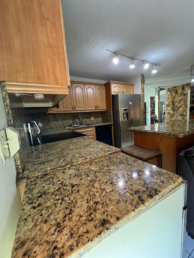 kitchen featuring decorative backsplash, stainless steel fridge with ice dispenser, a textured ceiling, and black dishwasher