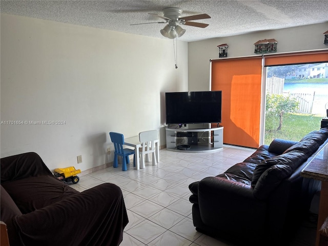 tiled living room with ceiling fan and a textured ceiling