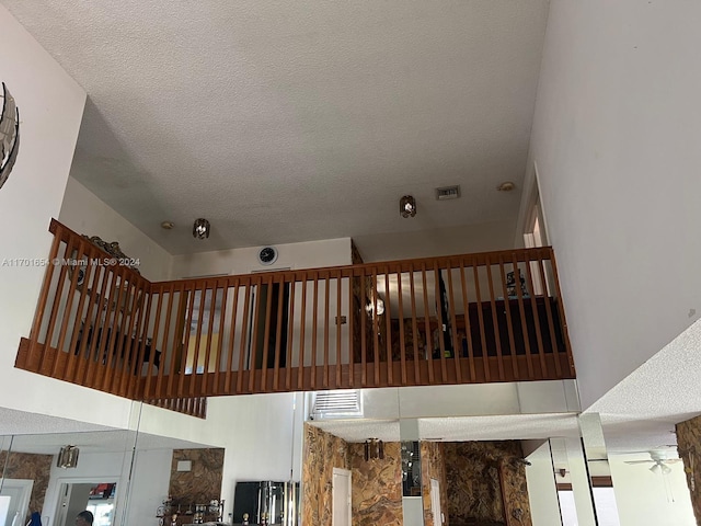 staircase with ceiling fan and a textured ceiling