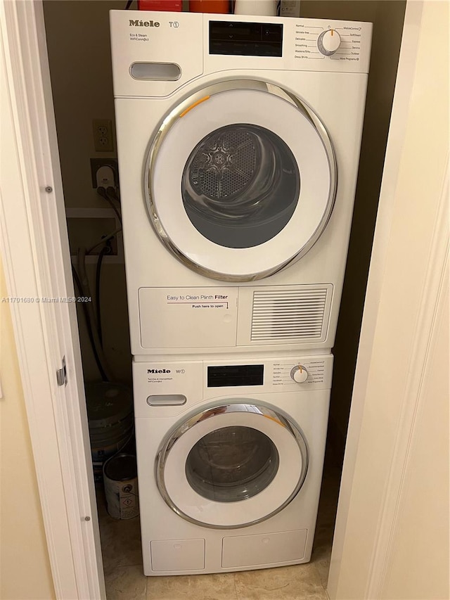 laundry room with light tile patterned floors and stacked washer and clothes dryer