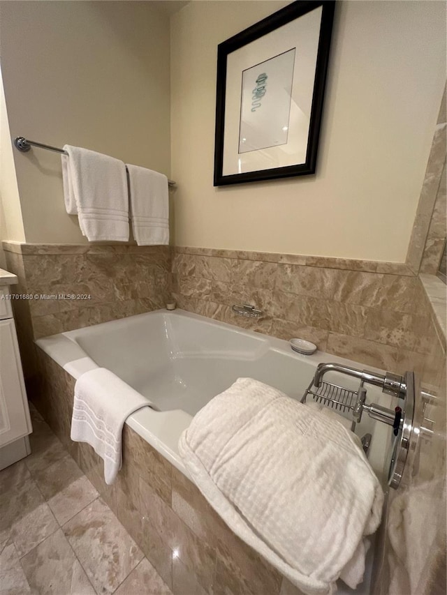 bathroom with vanity and a relaxing tiled tub