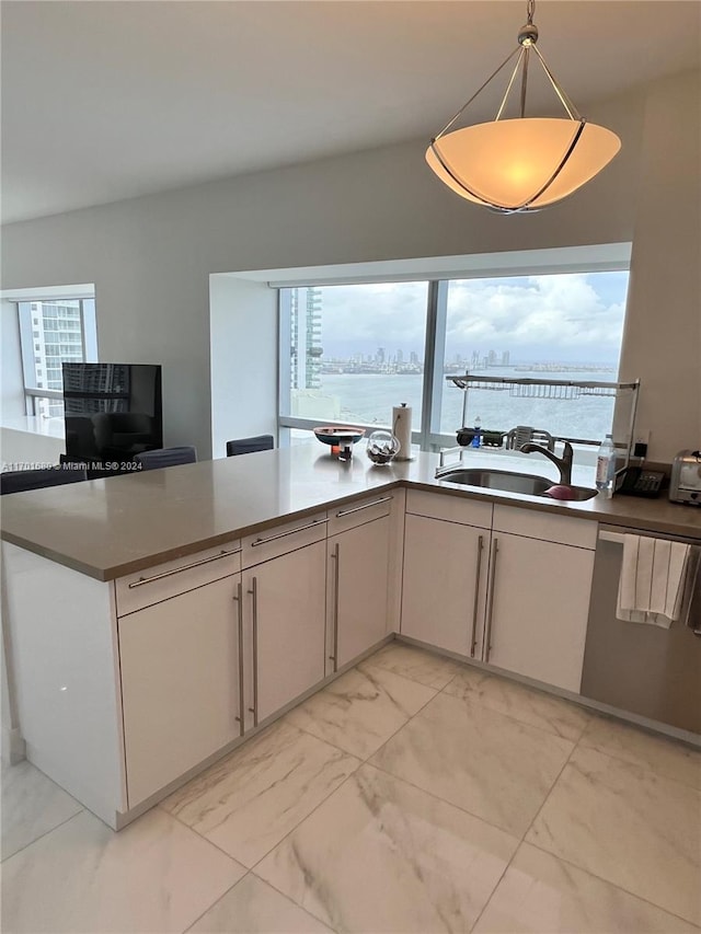 kitchen featuring pendant lighting, stainless steel dishwasher, and sink