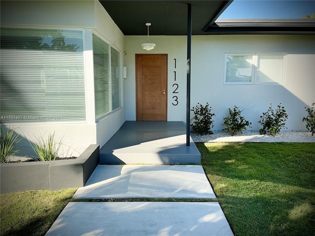 entrance to property featuring a lawn