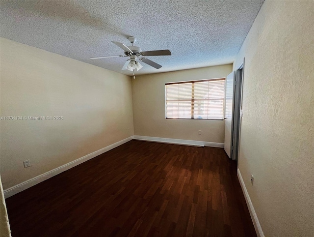 spare room featuring ceiling fan, dark wood-type flooring, and a textured ceiling