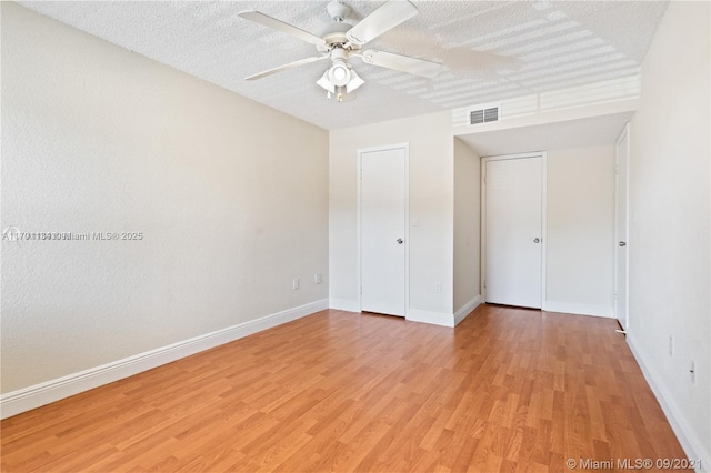 unfurnished room featuring ceiling fan, light hardwood / wood-style floors, and a textured ceiling