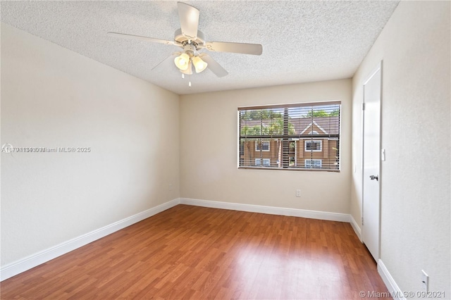 unfurnished room with ceiling fan, wood-type flooring, and a textured ceiling