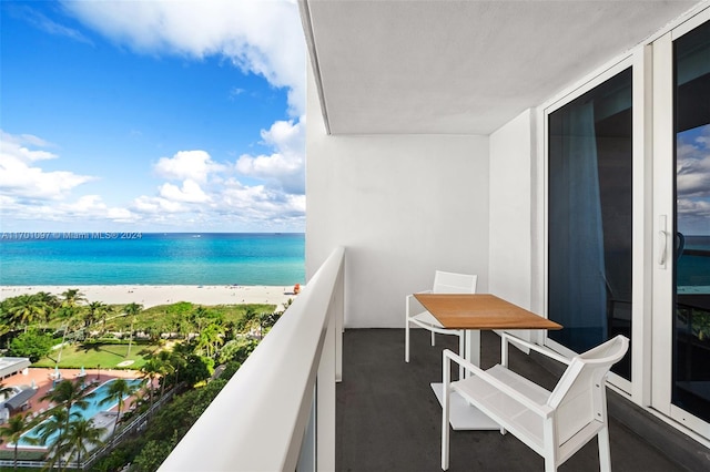 balcony featuring a view of the beach and a water view