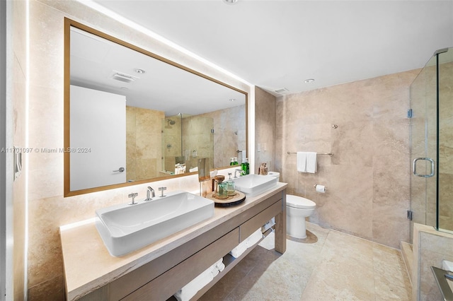 bathroom featuring an enclosed shower, vanity, toilet, and tile walls