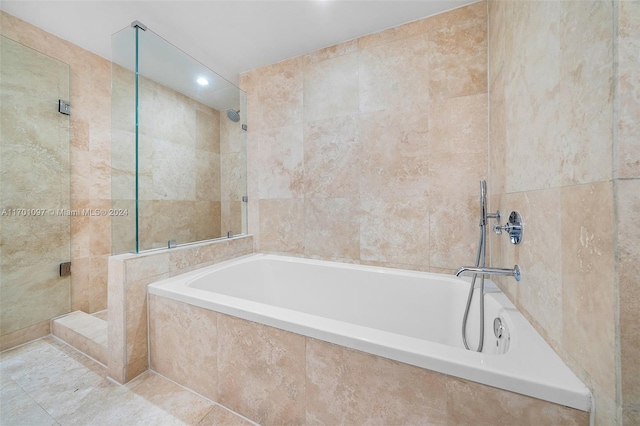 bathroom featuring tile patterned floors, separate shower and tub, and tile walls