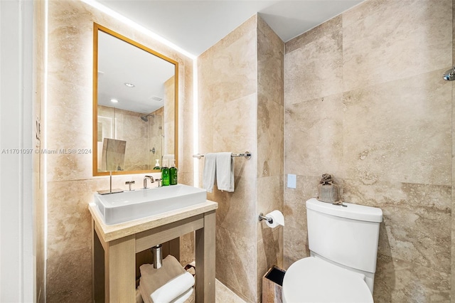 bathroom with sink, tile walls, and toilet