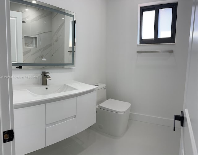 bathroom with tile patterned flooring, vanity, and toilet