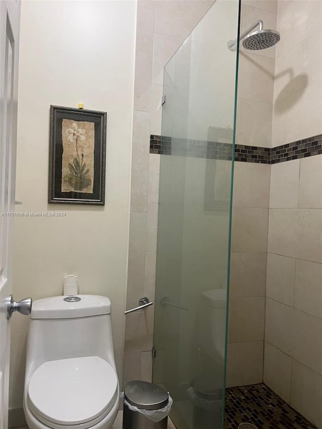 bathroom with toilet and a tile shower