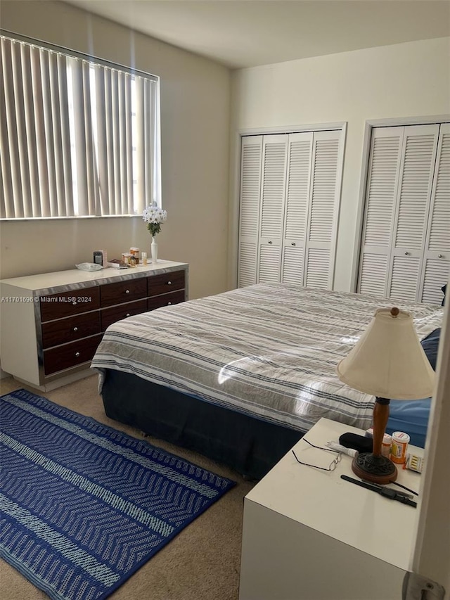 carpeted bedroom featuring two closets