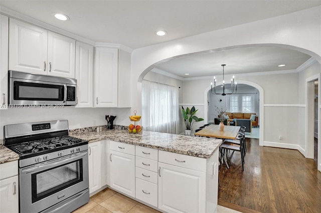 kitchen featuring white cabinets, light wood-type flooring, and stainless steel appliances