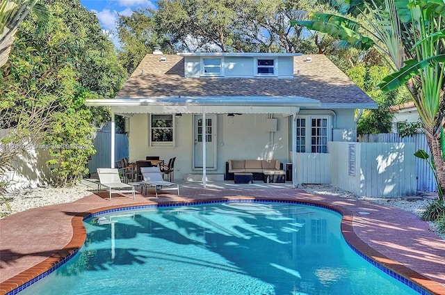 back of house with an outdoor hangout area, ceiling fan, a patio area, and a fenced in pool