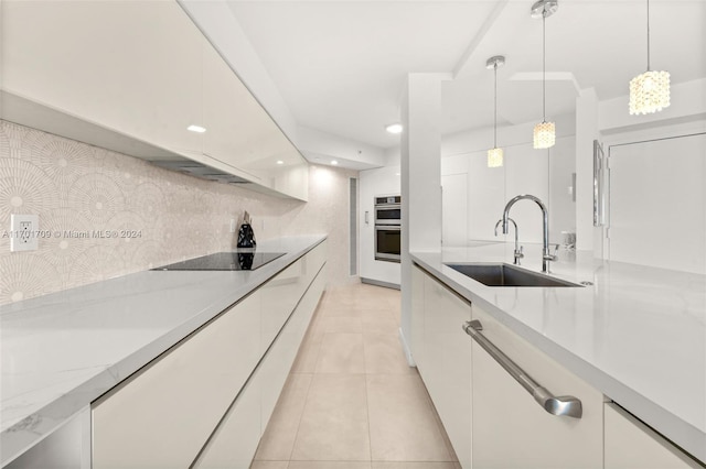 kitchen featuring white cabinets, backsplash, black electric cooktop, and sink