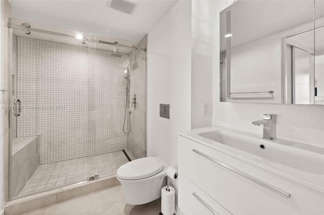 bathroom with tile patterned floors, a shower with door, vanity, and toilet