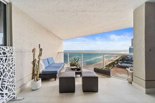 balcony featuring a beach view and a water view