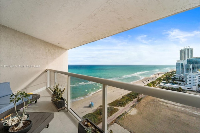 balcony featuring a water view and a view of the beach