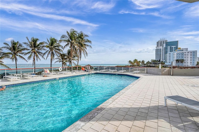 view of swimming pool with a patio area and a water view