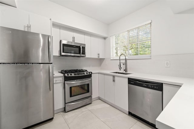 kitchen featuring white cabinets, decorative backsplash, sink, and stainless steel appliances