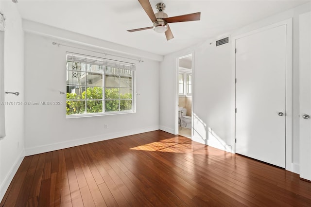 unfurnished bedroom with hardwood / wood-style floors, a closet, ensuite bathroom, and ceiling fan