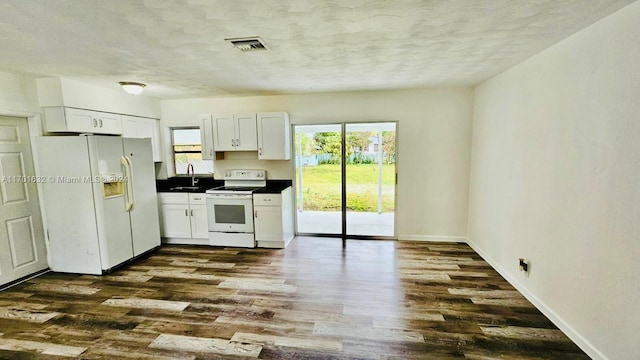 kitchen featuring white appliances, dark hardwood / wood-style floors, white cabinetry, and sink