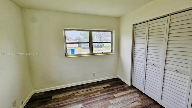 unfurnished bedroom featuring dark hardwood / wood-style flooring and a closet