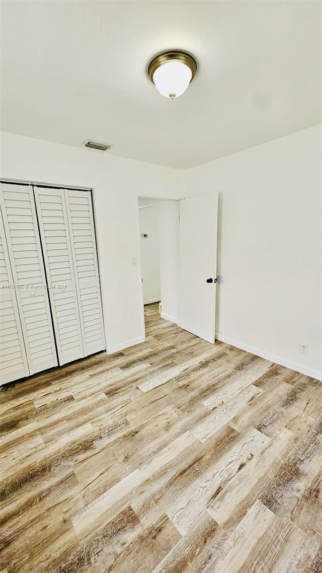 unfurnished bedroom with a closet and light hardwood / wood-style flooring