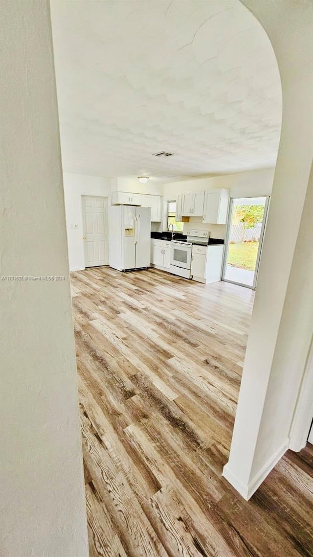 unfurnished living room with sink and light hardwood / wood-style floors