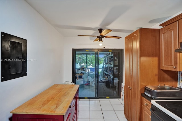 kitchen with butcher block counters, ceiling fan, light tile patterned floors, and exhaust hood