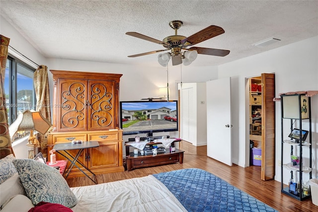 bedroom featuring a textured ceiling, dark hardwood / wood-style flooring, and ceiling fan