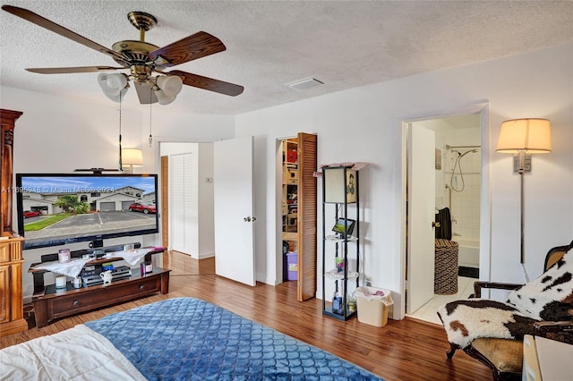 living room featuring a textured ceiling, ceiling fan, and dark wood-type flooring