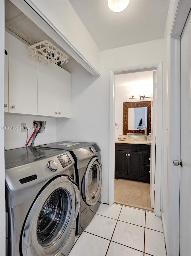 washroom featuring light tile patterned flooring, cabinets, and independent washer and dryer