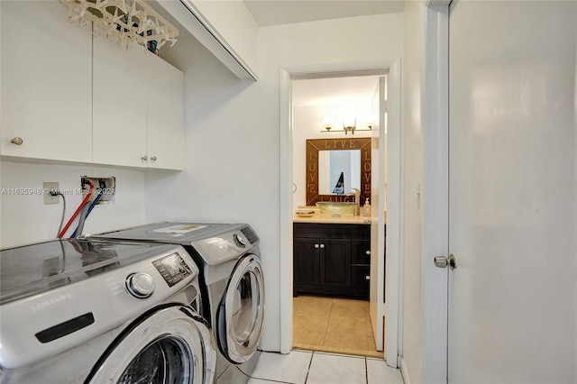 laundry room featuring independent washer and dryer, cabinets, and light tile patterned floors