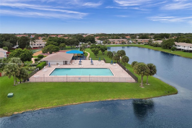 view of swimming pool with a patio area, a water view, and a yard