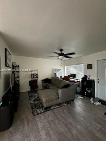 living room with ceiling fan and dark hardwood / wood-style flooring