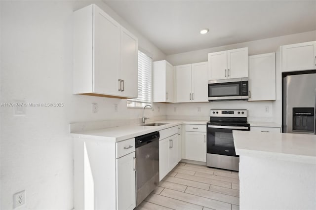 kitchen featuring sink, appliances with stainless steel finishes, and white cabinetry