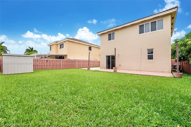 rear view of property with a lawn and a patio