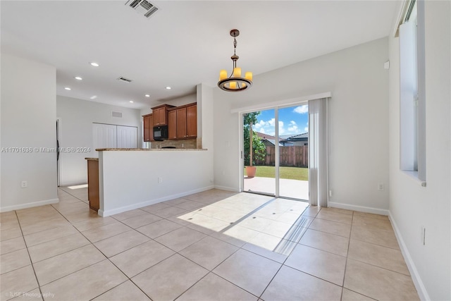 kitchen with kitchen peninsula, a chandelier, hanging light fixtures, and light tile patterned flooring