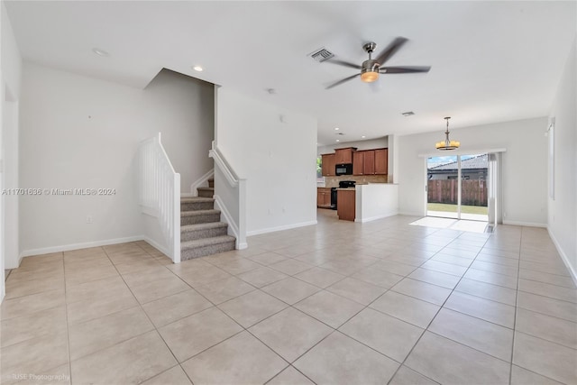 unfurnished living room featuring ceiling fan with notable chandelier and light tile patterned floors