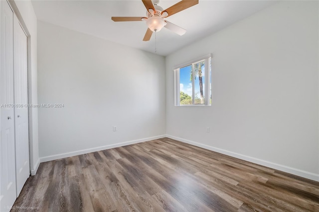 unfurnished bedroom featuring ceiling fan, a closet, and hardwood / wood-style flooring