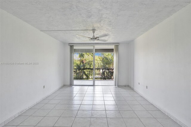 empty room with ceiling fan and light tile patterned flooring