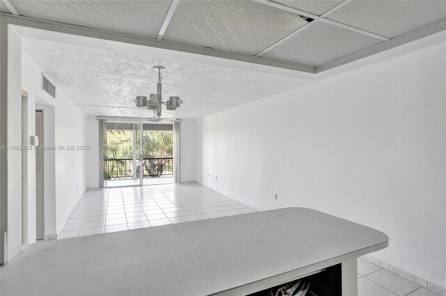 unfurnished dining area with light tile patterned flooring and a chandelier