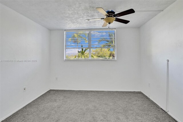 carpeted spare room with a textured ceiling and ceiling fan