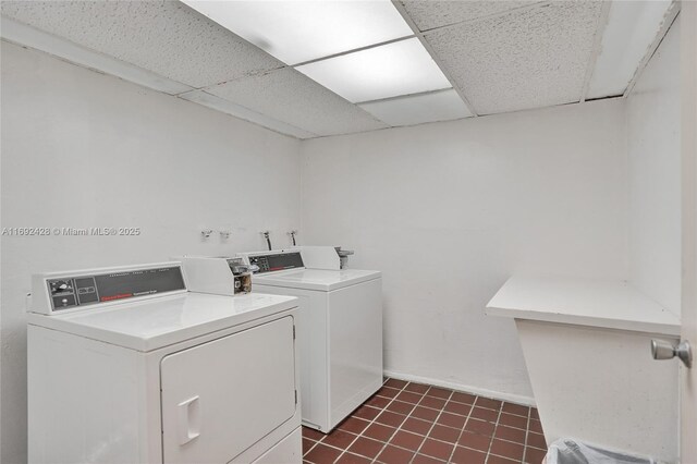 washroom featuring dark tile patterned flooring and washing machine and clothes dryer