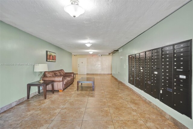 interior space featuring light tile patterned floors, a textured ceiling, and a mail area