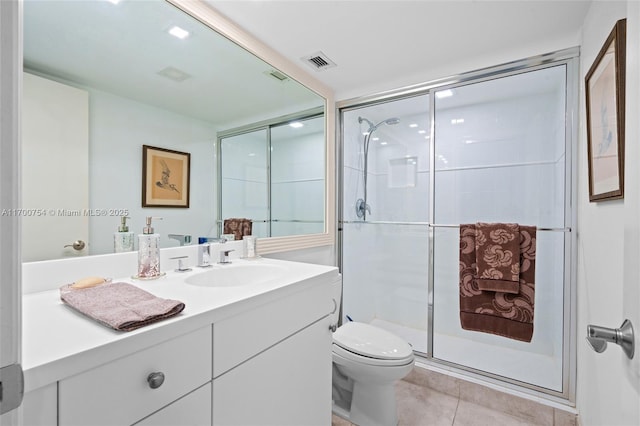 bathroom with toilet, a shower with shower door, tile patterned floors, and vanity