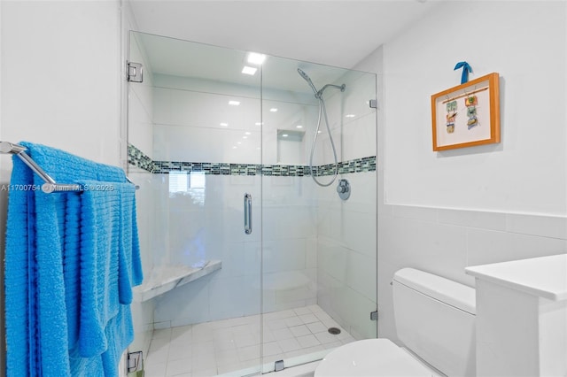 bathroom featuring toilet, walk in shower, and tile walls