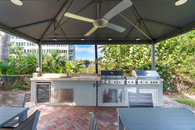 view of patio featuring wine cooler, a grill, exterior kitchen, and a gazebo